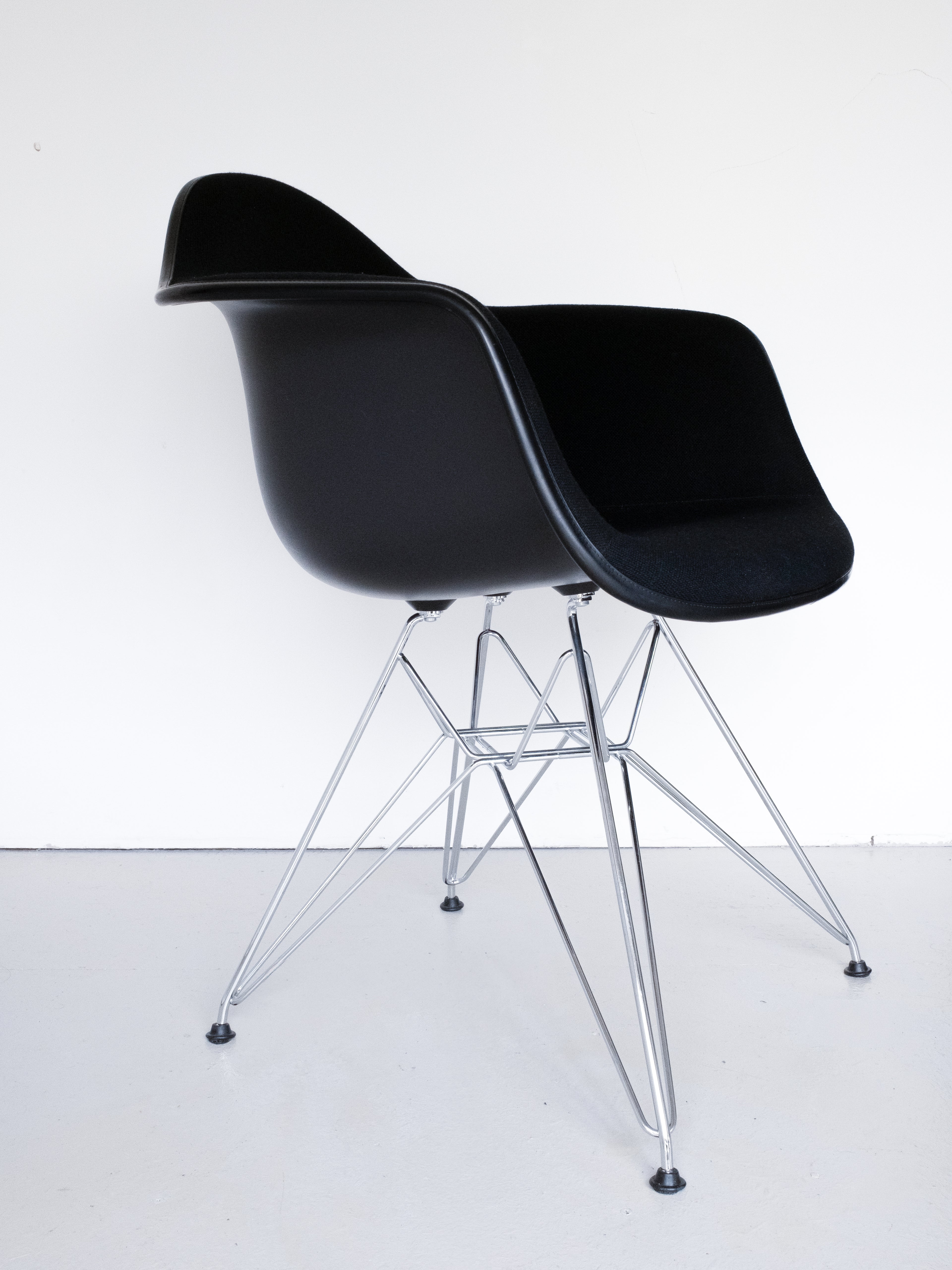 Eames Plastic Armchair DAR by Charles and Ray Eames for Vitra, 3/4 side profile, black molded plastic chair with chrome legs
