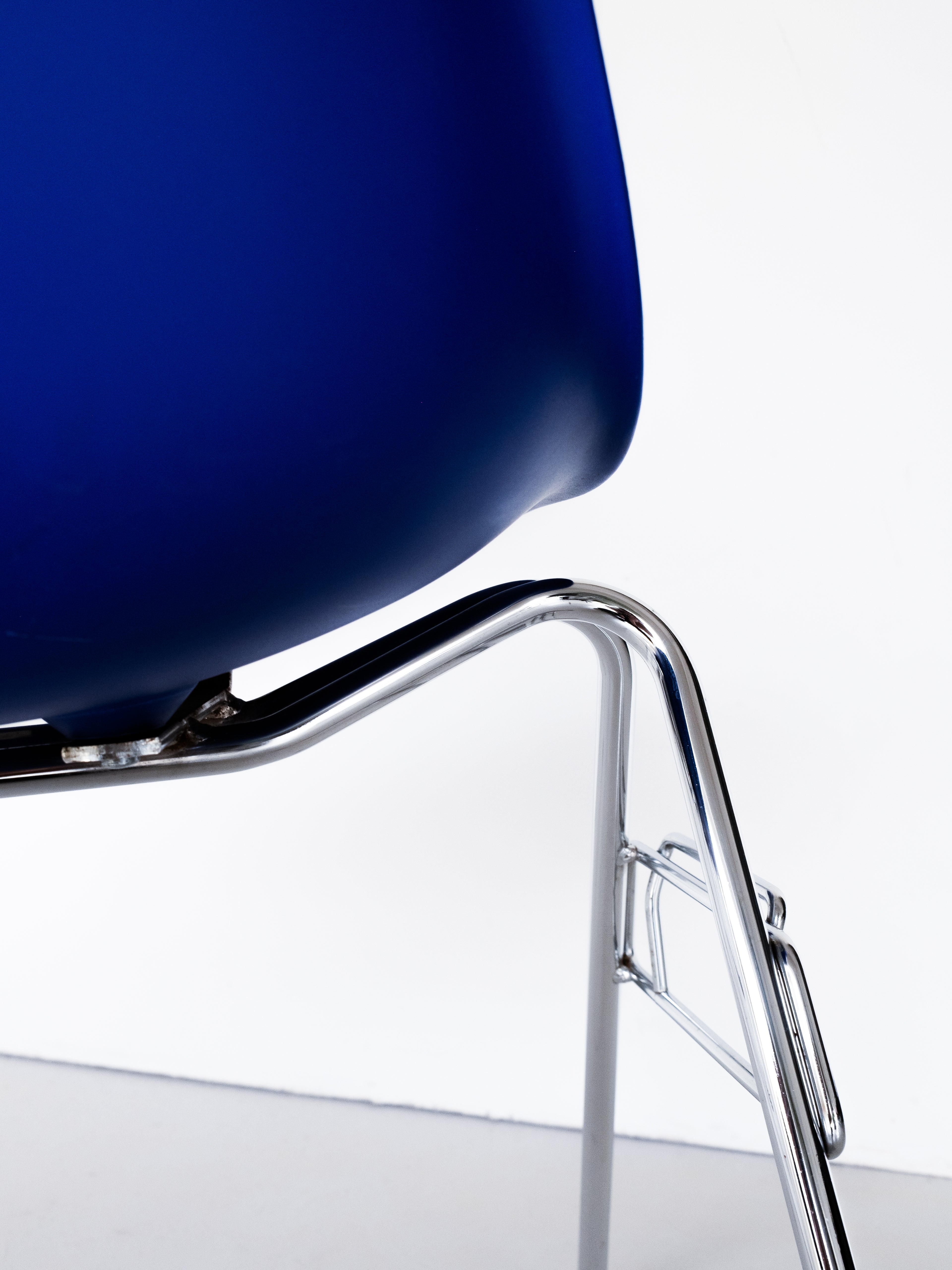 Blue Eames chair with chrome legs by Vitra, mid-century modern design